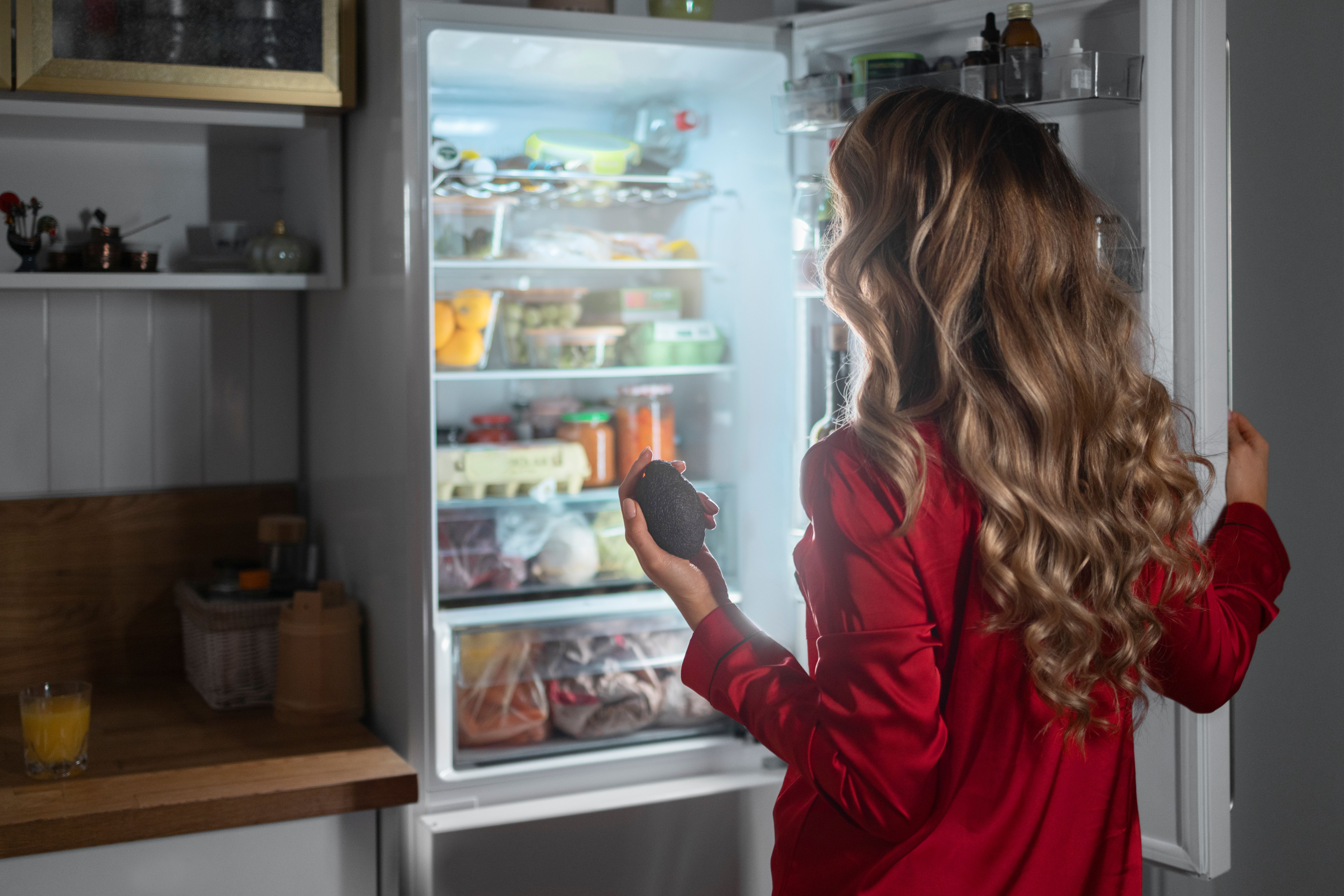 medium-shot-woman-checking-fridge-night.jpg